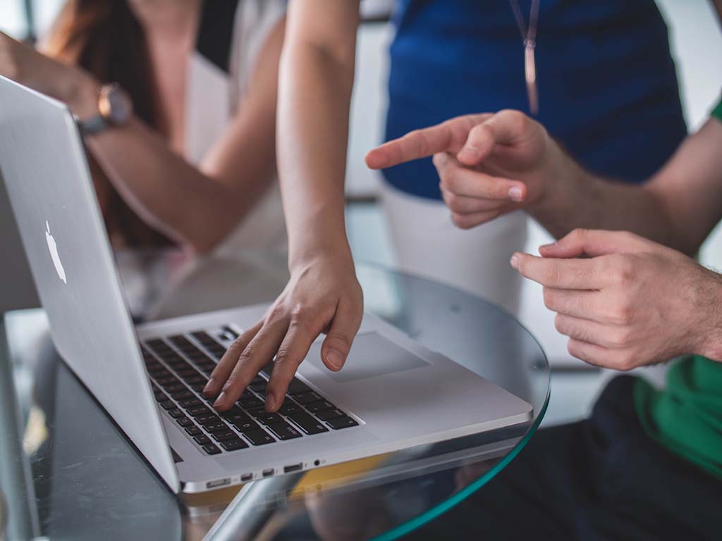 Close up of people working on a laptop