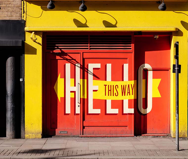 Doorway painted with words Hello This Way