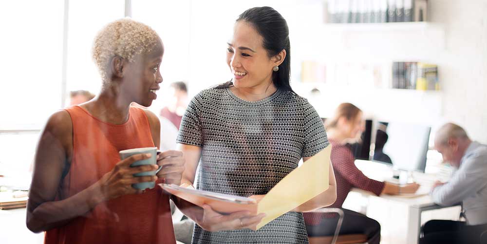 Business women discussing a folder of work