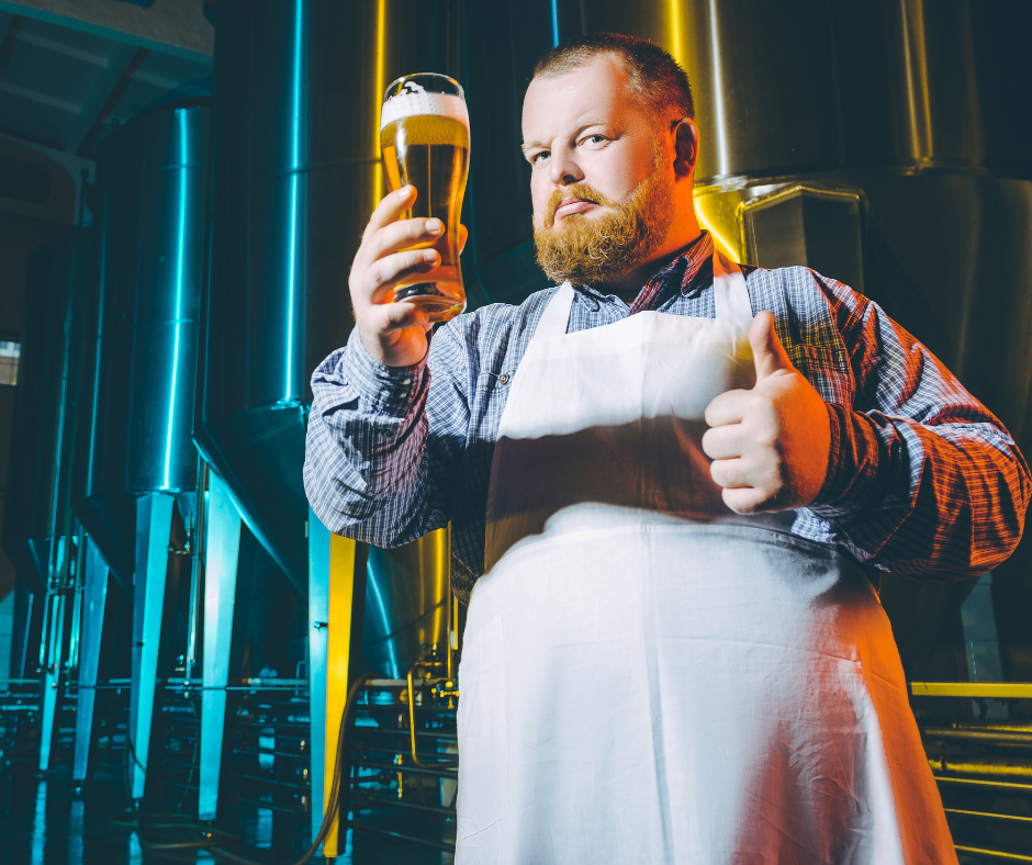 Brewer holding a pint of beer giving a thumbs up